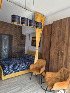 a bedroom with a bed and two chairs at WILLA VASCO BOSMAN in Rewa