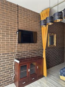 a brick wall with a tv on a wall at WILLA VASCO BOSMAN in Rewa