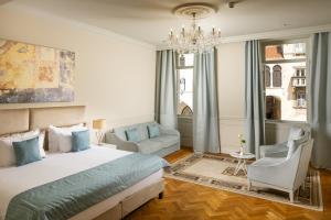 a bedroom with a bed and a couch and a chandelier at Heritage hotel Santa Lucia in Split +48 photos