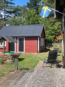 a house with a flag and a chair in front of it at Röda huset in Åhus
