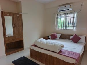a bedroom with a bed and a mirror and a window at hotelnishainn in Rānchī