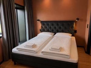 a bed with white blankets and pillows on it at Flakstad beach house Silo A in Vareid
