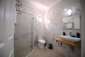 a white bathroom with a sink and a toilet at Rijeka Pansiyon in Ayvalık +59 photos