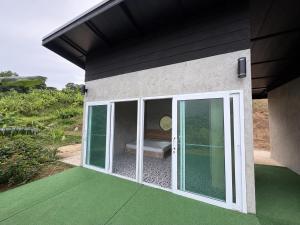 a house with sliding glass doors on a patio at ภูหลงหมอก รีสอร์ท in Ban Huai Lat