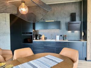 a kitchen with blue cabinets and a table with chairs at Flakstad beach house Silo A in Vareid