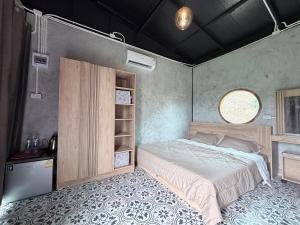 a bedroom with a large bed and a window at ภูหลงหมอก รีสอร์ท in Ban Huai Lat