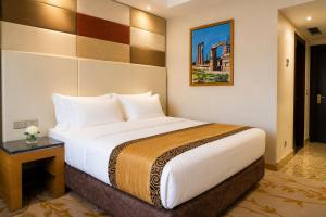 a hotel room with a large bed and a table at Attawfeek Plaza in Tripoli +36 photos