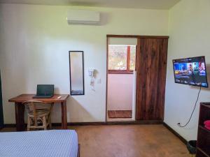 a room with a desk and a laptop on a table at Zipolite Maracuya Hostel & Rooms in Zipolite