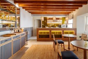 a restaurant with tables and chairs and a bar at Gran Hotel Margalida by Annua Signature in Banyalbufar