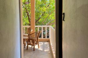 a porch with two chairs and a table on a balcony at Zipolite Maracuya Hostel & Rooms in Zipolite
