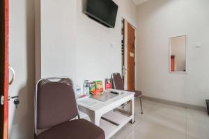 a room with a desk and a tv on a wall at RedDoorz Plus near Palembang Airport 3 in Palembang