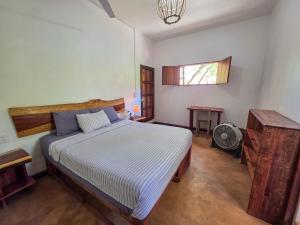 a bedroom with a large bed and a window at Zipolite Maracuya Hostel & Rooms in Zipolite