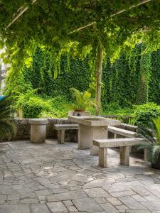 a group of benches sitting in a park at Cozy house Luana in Lopud