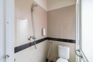 a bathroom with a shower and a toilet at RedDoorz Plus near Palembang Airport 3 in Palembang +15 photos