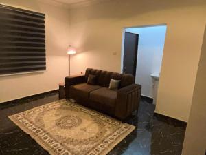 a living room with a brown couch and a rug at Aaron Obibi Court in Owerri