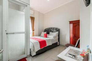 a bedroom with a bed with a red blanket at RedDoorz Plus near Palembang Airport 3 in Palembang