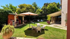 a yard with a table and chairs and an umbrella at Kaloudis Studios & Apartments in Dassia