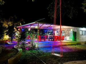a group of people sitting at a restaurant at night at Saiesh resort in Alibaug