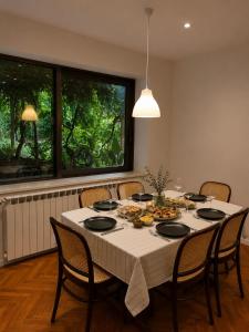 a dining room table with a white table cloth and chairs at Cozy house Luana in Lopud +15 photos