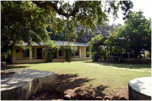 a house with a large yard in front of it at Saiesh resort in Alibaug +6 photos