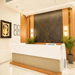 a reception desk with a chalkboard on the wall at Hotel Mangla Inn - Dwarka in Dwarka