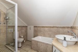 a bathroom with a tub and a sink and a toilet at Alfred View in Port Alfred +29 photos