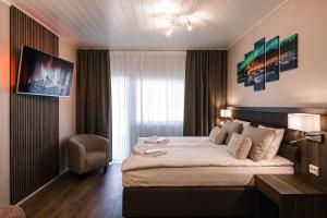 une chambre d'hôtel avec un lit et une chaise dans l'établissement Hotel Boreas, à Rovaniemi