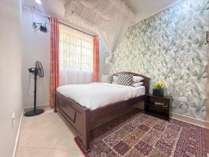 a bedroom with a bed and a large window at MILIMANI DRIVE LIVINGs in Kisumu