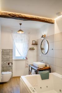 a bathroom with two sinks and a toilet and a mirror at Brkinka Apartments in Vremski Britof +55 photos