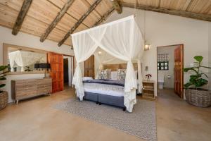a bedroom with a canopy bed in a room at Glen Harry Game Reserve in Graaff-Reinet +58 photos