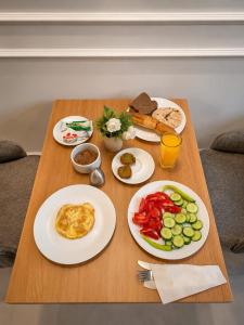 a wooden table with plates of breakfast food on it at ReLax havanaa in Cairo