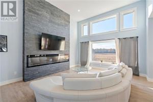 a living room with a white couch and a fireplace at Quarto Gananoque #1 in Gananoque
