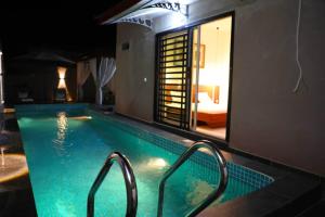 a swimming pool with two metal rails in a room at Dream Assinie V in Mafia +16 photos