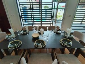 a dining room table with plates and glasses on it at Dream Assinie V in Mafia