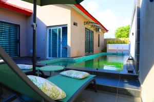 a swimming pool with a table and an umbrella at Dream Assinie V in Mafia