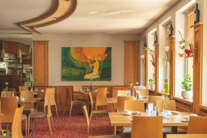 a restaurant with tables and chairs and a painting on the wall at Klaus im Weinviertel in Wolkersdorf