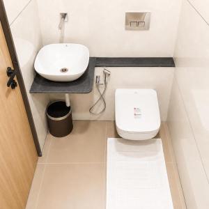 a bathroom with a white toilet and a sink at Hotel Mangla Inn - Dwarka in Dwarka +12 photos