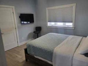 a bedroom with a bed and a window and a television at Quarto Gananoque #1 in Gananoque
