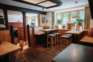 a restaurant with wooden floors and tables and windows at Das Geringer in Schladming