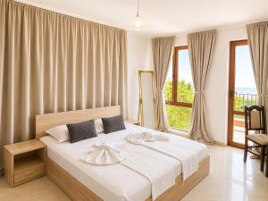 a bedroom with a bed and a large window at Stefaniya Apartments in Sozopol +132 photos