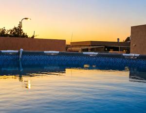 Ein Swimmingpool mit dem Sonnenuntergang im Hintergrund in der Unterkunft וילת אתרוג - וילה וצימר מושלמים עם בריכה באשלים in Ashalim + 33 Fotos