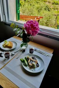 a table with two plates of food and a vase of flowers at Agriturismo Yucca in Giustenice
