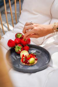 a woman holding a plate of strawberries on a plate at Quintessia in Orvault +71 photos
