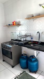 a kitchen with a stove and a sink at Casa Arembepe in Camaçari