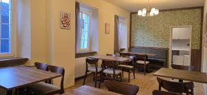 a restaurant with wooden tables and chairs and windows at Drei Schweizer Hotel in Neuwied
