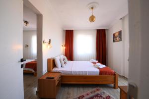 a small bedroom with a bed and a window at Rijeka Pansiyon in Ayvalık