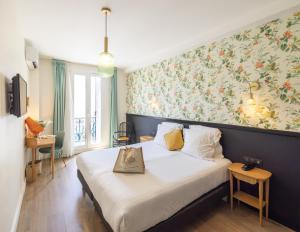 a hotel room with a bed with a bag on it at Hotel La Villa Nice Promenade in Nice