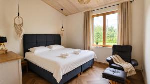 a bedroom with a bed and a chair and a window at Kaasaegne puhkemaja in Kersalu