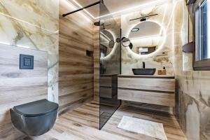 a bathroom with a black toilet and a mirror at Kuća za odmor Šum slapa in Karlovac +35 photos