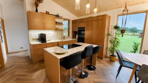 a kitchen with wooden cabinets and a table and chairs at Kaasaegne puhkemaja in Kersalu